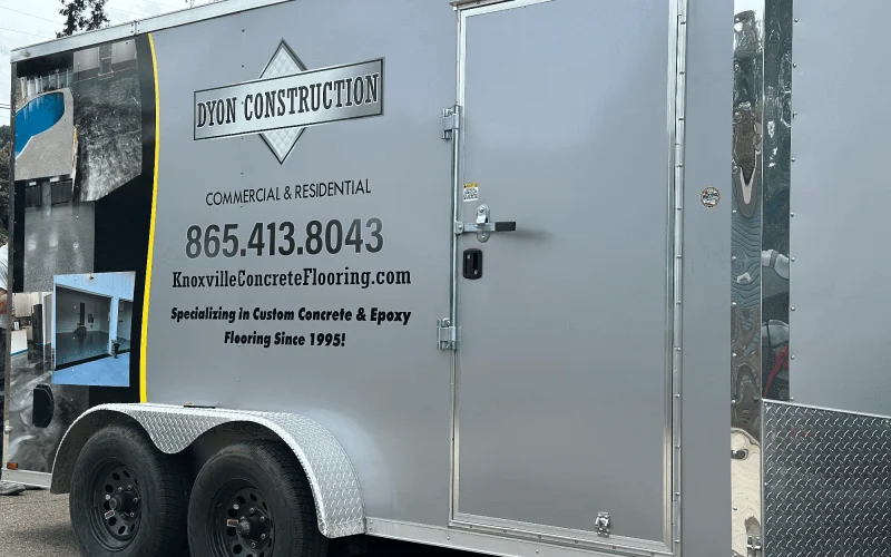 Photo showing the side of our trailer, where we have our number, website and our name Dyon Construction